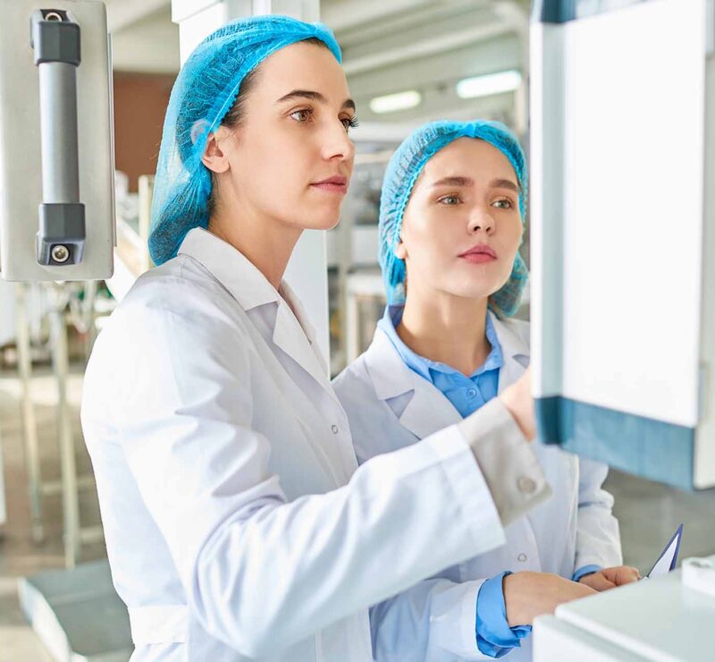 Young technicians operating machine in cleanroom facility