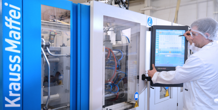 KeyPrecision engineer operating a Krauss Maffei injection moulding machine