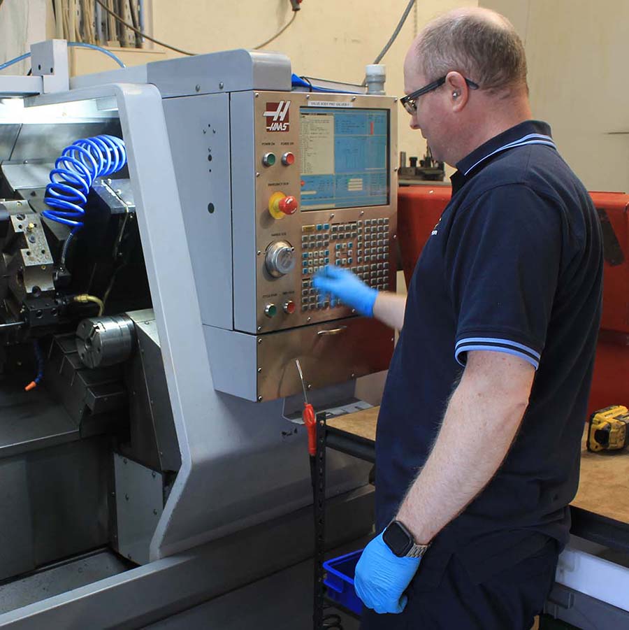 KeyPrecision engineer operating a Haas CNC machine